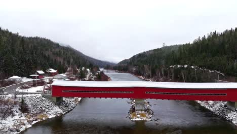 covered-bridge-with-a-little-bit-of-snow-crossing-a-river-in-quebec,-canada