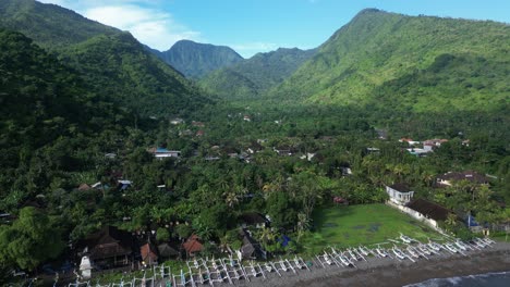 Amed-in-the-North-of-Bali-on-a-sunny-morning-with-beach-and-mountain-scenery,-aerial
