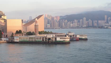 Ferry-boat-sitting-moored-await-next-departure-time,-backdrop-Hong-Kong-city