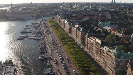 Strandvägen-and-Strandkajen,-Stockholm-during-sunny-evening-with-old-apartment-buildings,-traffic,-boats-and-skyline-visible