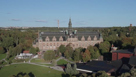 Breite-Luftaufnahme-Des-Nordischen-Museums-Mit-Kaknästornet-Und-Wald-Im-Hintergrund-An-Einem-Sonnigen-Abend-Auf-Djurgården-In-Stockholm,-Schweden