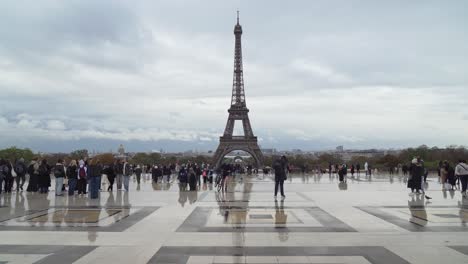 Vögel-Fliegen-Auf-Dem-Trocadero-Platz,-Während-Menschen-Spazieren-Gehen-Und-Den-Eiffelturm-Beobachten