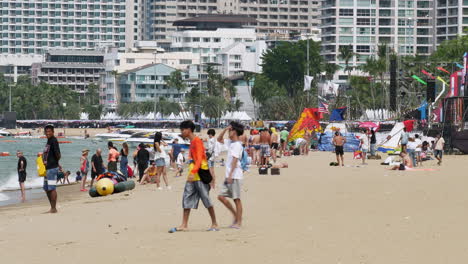 Local-and-foreign-tourists-are-strolling,-sunbathing,-and-taking-pictures-at-beachfront-of-Pattaya-in-the-province-of-Chonburi-in-Thailand