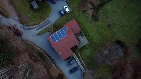 Large-house-with-a-red-roof-on-Geradmer,-France-filmed-by-a-drone-rotating-and-flying-upwards