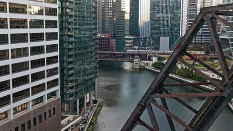 Aerial-view-following-a-train-on-the-Lake-Street-Bridge,-fall-day-in-downtown-Chicago