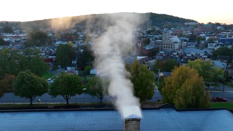 Smoke-coming-out-of-chimney-during-sunrise-in-small-town-America