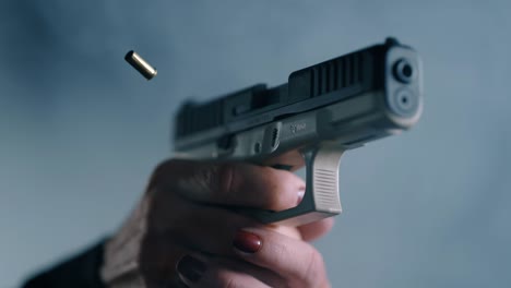 Person-with-Red-Fingernail-Polish-Firing-Gun-and-Ejecting-Casing