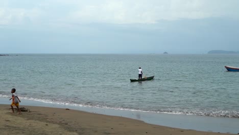 Man-paddling-a-canoe-on-pacific-coast-of-Colombia,-Bahia-Solano
