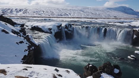 Powerful-Godafoss-waterfall-stream-into-crystal-clear-water-pool,-Iceland