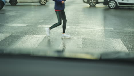 People-walking-across-pedestrian-street-crossing-on-a-a-rainy-day