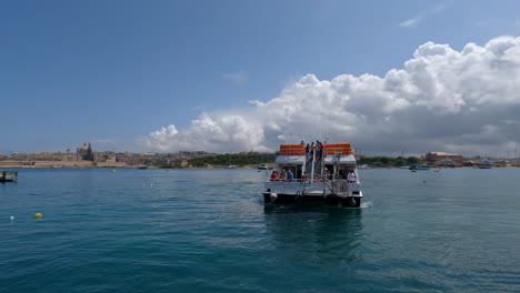 Touristic-boat-full-with-tourists-dock-in-port-of-Valletta,-Malta