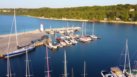 A-marina-in-a-cove-in-Georgian-Bay-with-yachts-and-other-kinds-of-boats,-a-lighthouse-on-the-dock,-Quebec,-Canada
