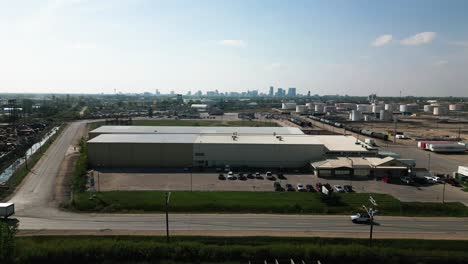 Establishing-4K-Time-lapse-Drone-Out-Aerial-Shot-of-Industrial-Factory-Semi-Zone-Manufacturing-Landscape-Distribution-Center-District-in-Downtown-City-Winnipeg-Manitoba-Canada-in-Distance