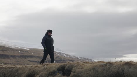 Paseo-Turístico-En-El-Nublado-Paisaje-Islandés-Con-Una-Enorme-Montaña-En-El-Fondo