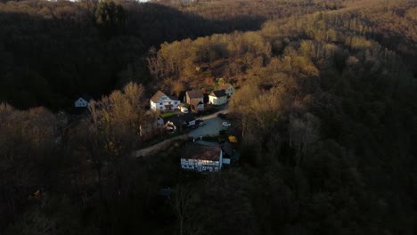 Un-Pequeño-Pueblo-De-Casas-Con-Entramado-De-Madera-Durante-La-Puesta-De-Sol-En-Un-Bosque-En-Alemania