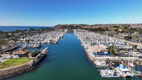 Boats-Moored-At-Dana-Point-Harbor-With-Yacht-Club-And-Restaurant-In-California,-USA