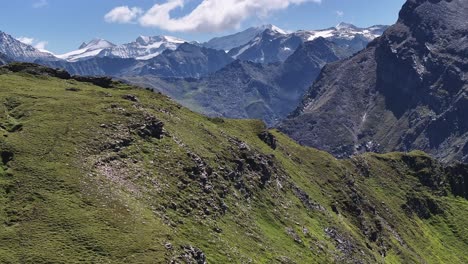 daytime-mountain-layers-landscape-dynamic-slow-stable-wide-aerial-drone-shot-in-alpine-environment-and-lush-green-grass