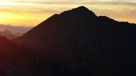 Berglandschaft-Dynamische-Langsame-Stabile-Drohnenaufnahme-Bei-Sonnenuntergang-In-Alpiner-Umgebung-Mit-Sonneneruption
