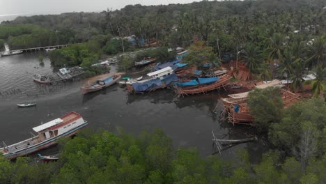 Wide-shot-of-local-boat-construction-site-at-Belitung-island-Indonesia,-aerial