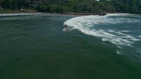 60-FPS-Slow-Motion-Aerial-Drone-Shot-of-Caucasian-Female-Surfer-Catching-and-Riding-a-Wave-in-Southern-Sri-Lanka