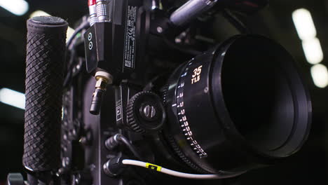 Modular-professional-cinema-camera-with-sensor-block-separated-from-the-body,-high-end-cinema-lens-focus-ring-being-turned-by-a-remote-focus-motor-by-a-focus-puller