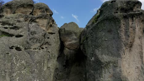 Retreating-drone-shot-of-Karadzhov-Kamak,-a-natural-rock-formation-venerated-by-the-ancient-Thracians-as-the-place-of-the-dead,-located-in-Plovdiv-province-in-Bulgaria