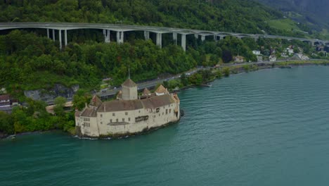 CHILLON-CASTLE-Switzerland-city-is-coming-back-and-there-are-many-trees-around-the-castle,-and-weaves-in-the-water