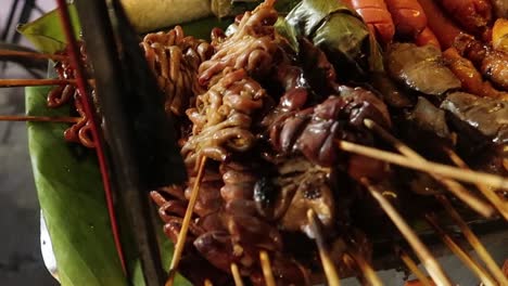 Diverse-grilled-meat-in-BBQ-skewers-on-street-food-cart-at-thai-night-market