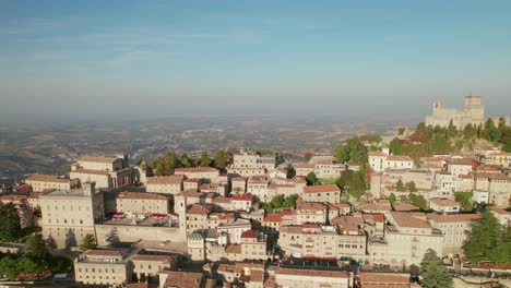 San-Marino,-Italy,-city-on-a-mountain,-city-building,-drone-orbit-view
