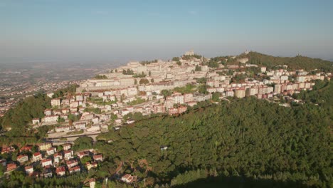 San-Marino,-Italy,-city-on-a-mountain,-city-building,-drone-pull-out-view