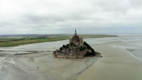 Die-Drohnenkamera-Des-Mont-Saint-Michel-Ist-Auf-Dem-Weg-Zu-Dem-Ort-Und-Es-Gibt-Viele-Touristen