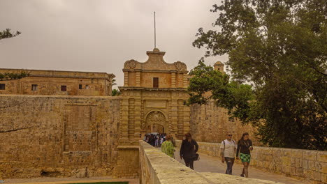 People-walking-enjoying-the-view-of-the-entrance-gate-of-Mdina-in-Malta