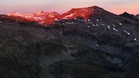 red-pink-mountain-landscape-dynamic-slow-stable-drone-shot-at-sunset-in-alpine-environment