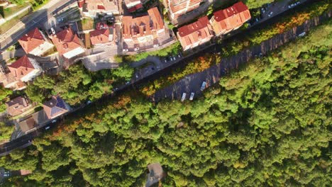 San-Marino,-Italy,-top-down-drone-view,-fly-into-the-city-from-forest