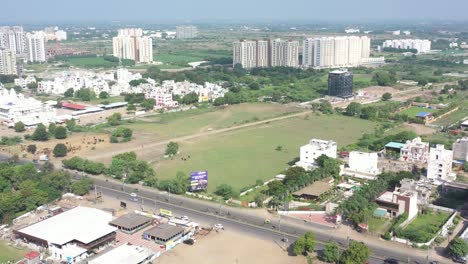 Rajkot-city-aerial-view-The-drone-is-moving-round-and-there-is-a-large-plain,-in-which-cows-and-buffaloes-are-visible