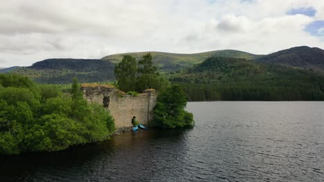 Ethereal-Heights:-Aerial-View-of-The-Lush-Forests-and-Calm-Waters-of-Loch-An-Eilein-and-an-Ancient-Castle,-Nestled-in-The-Cairngorms-in-The-Scottish-Highlands,-Scotland