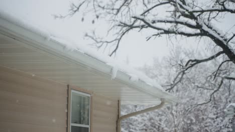 An-ice-dam-building-up-on-a-roof-near-the-gutters-during-snowstorm