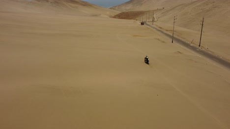 Ein-Motorradfahrer,-Der-In-Den-Dünen-Einer-Wüste-Fährt