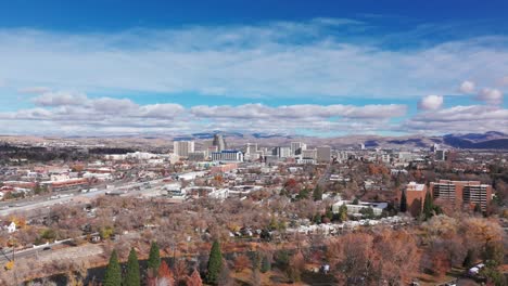 Drone-shot-flying-towards-downtown-Reno,-Nevada-on-a-partly-cloudy-day