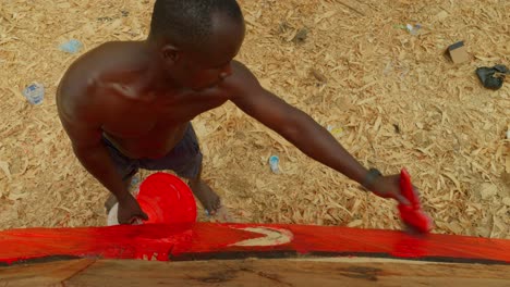 black-male-worker-african-paint-in-red-a-wooden-fisherman-boat