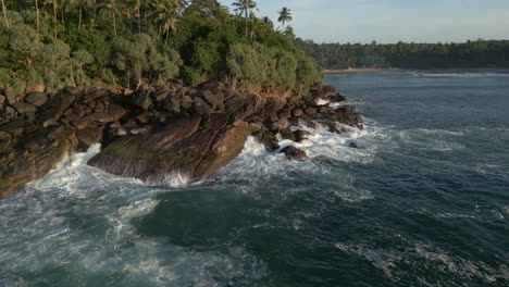Aufnahme-Einer-Luftdrohnenaufnahme-Von-Wellen,-Die-Gegen-Felsen-Krachen,-60-Fps-Mit-Einer-Bucht-Im-Hintergrund-An-Der-Südküste-Sri-Lankas
