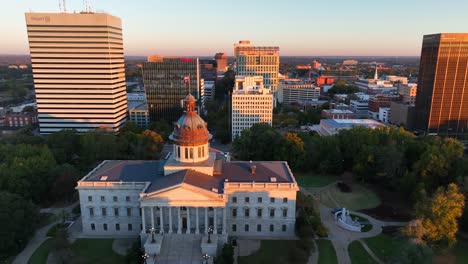 South-Carolina-State-House-with-downtown-Columbia,-SC-skyline-in-the-background-during-golden-hour-sunrise