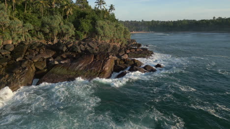 Low-Aerial-Drone-Shot-of-Waves-Crashing-into-Rocky-Tropical-Coastline-in-South-Sri-Lanka