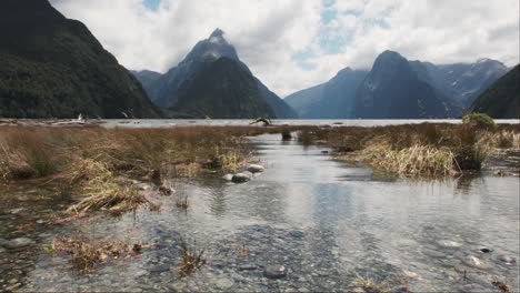 Milford-Sound-majestic-peaks-and-lush-greenery-mirror-themselves-on-shallow-waters-of-the-fiord
