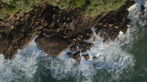 Statische-Luftdrohne-Von-Oben-Nach-Unten-Aufnahme-Von-Wellen,-Die-Sanft-Gegen-Felsen-An-Der-Felsenküste-Im-Tropischen-Land-Sri-Lanka-Krachen