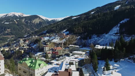Beautiful-European-mountain-city-with-church-in-winter-season,-aerial-view