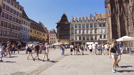 people-walking-on-Place-de-la-cathedral-Strasbourg-on-a-warm-summer-day