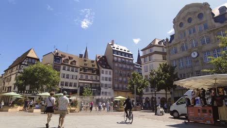 Menschen,-Die-An-Einem-Warmen-Sommertag-Auf-Dem-Straßburger-Marktplatz,-Place-Kléber,-Spazieren-Gehen-Und-Rad-Fahren
