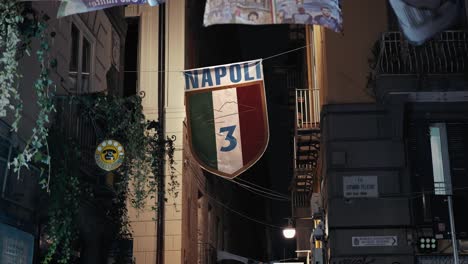 Escudo-De-Fútbol-De-Napoli-Exhibido-En-El-Callejón-De-La-Ciudad,-Escena-Nocturna