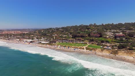 Menschen-Schwimmen-Und-Surfen-Am-Del-Mar-Beach-Mit-Powerhouse-Park-In-San-Diego,-Kalifornien,-USA